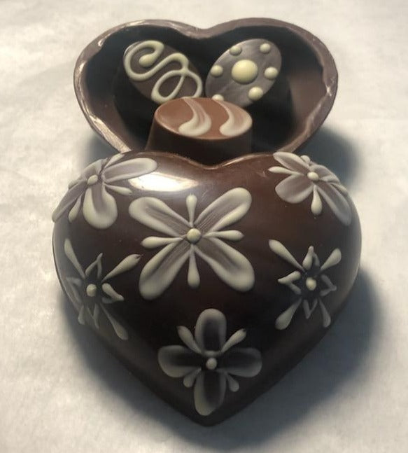 Boîte coeur en chocolat peinte à la main avec trois chocolats.